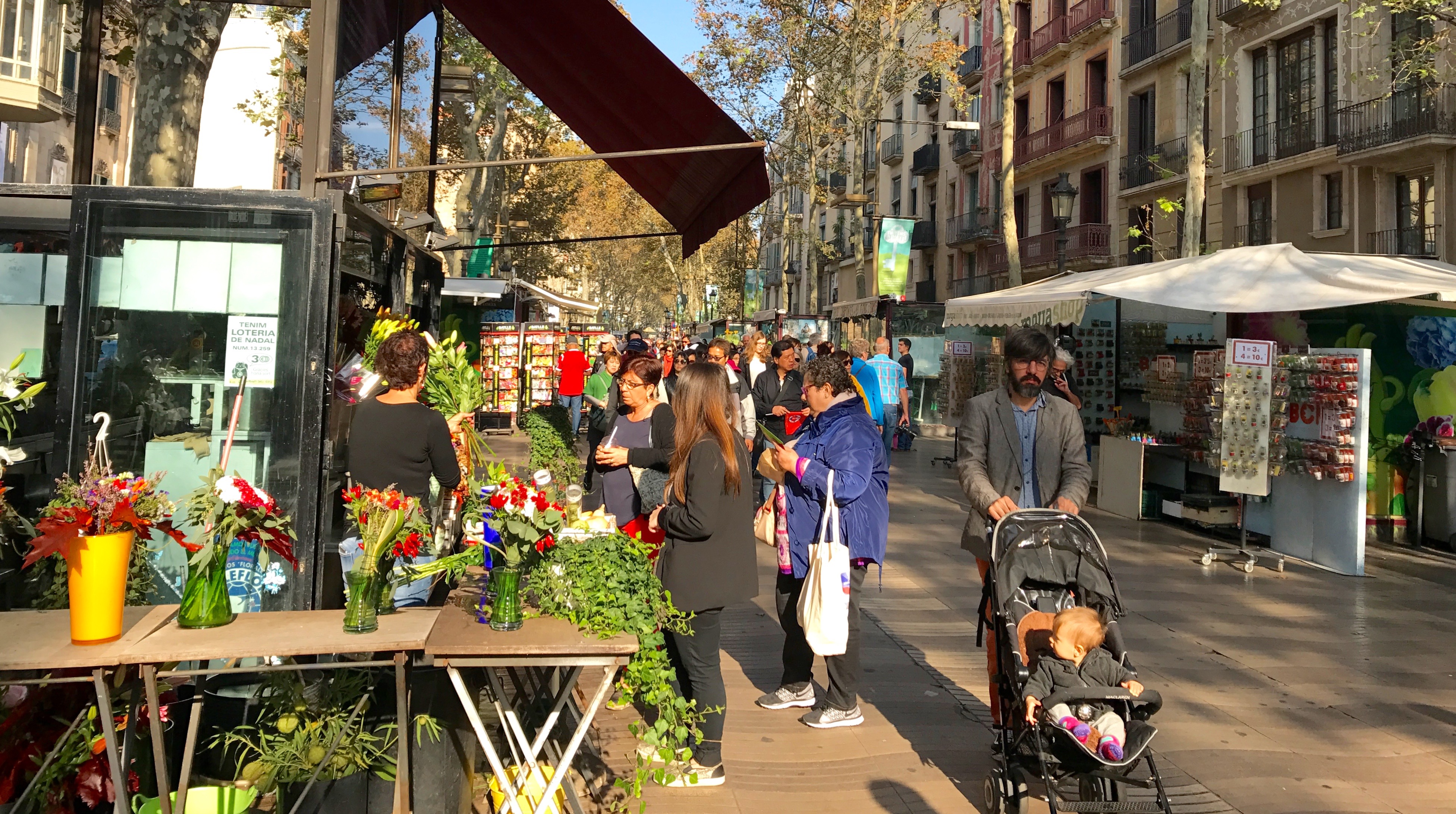 La Rambla - Barcelona's most famous street, filled with flower vendors, souvenir kiosks, cafes and throngs of people.
