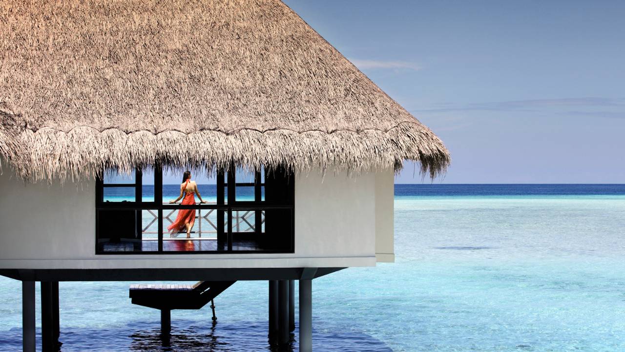 Thatched beach bungalows and water villas. Four Seasons Resorts Maldives.