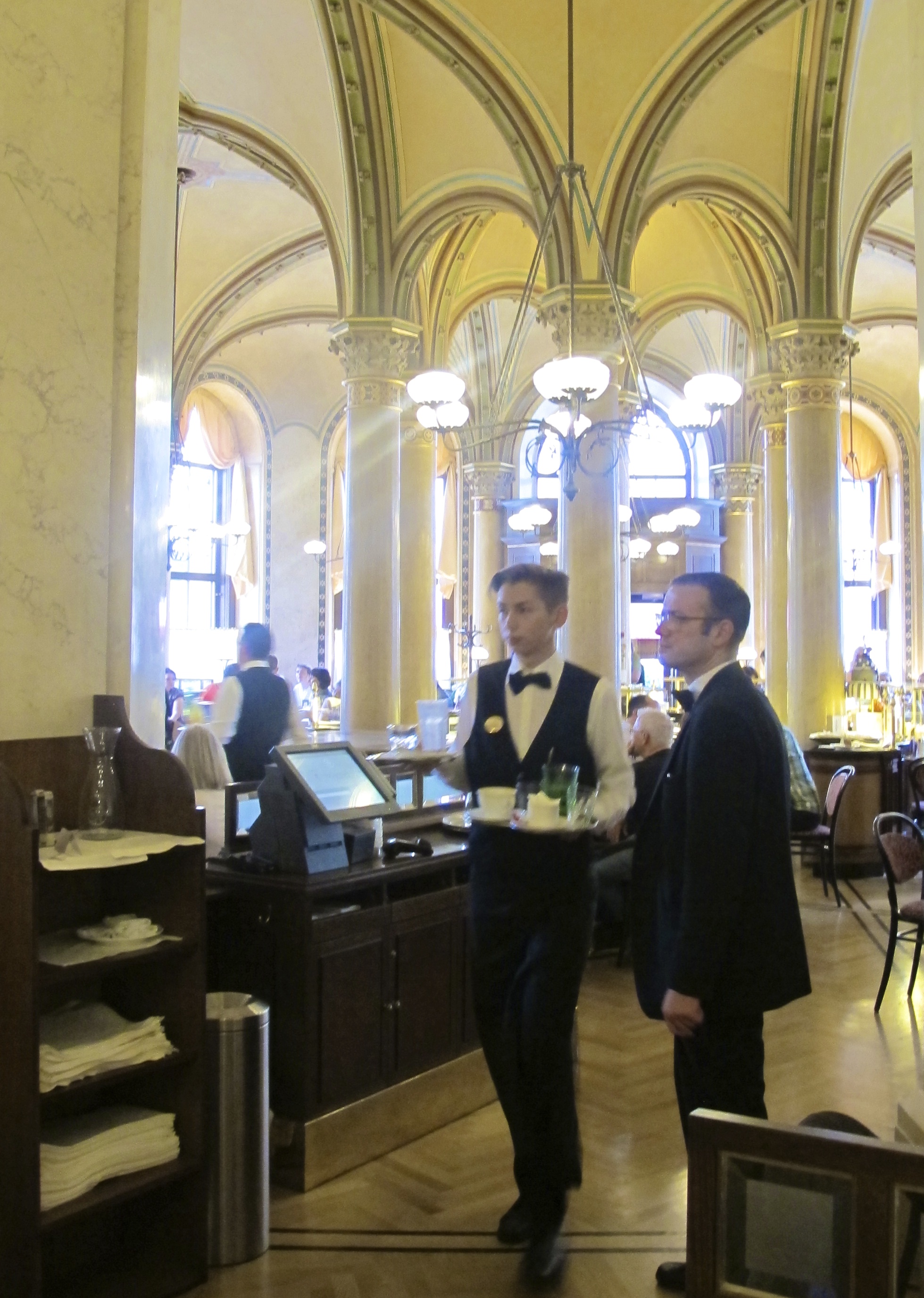 Elegant waiters in black ties and vests at Café Central.