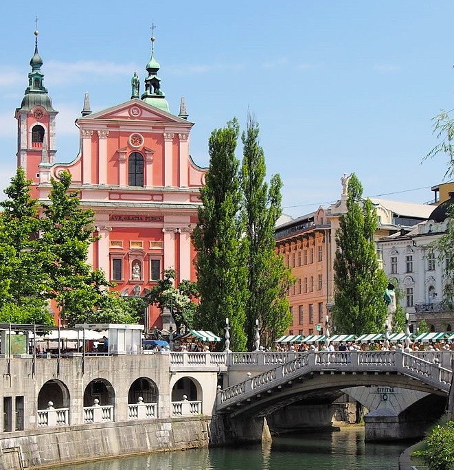 The ornate and vibrantly-pink Franciskanska Cerkev (Franciscan Church) and the the Triple Bridge, designed by Jože Plečnik - beloved Ljubljana landmarks. 